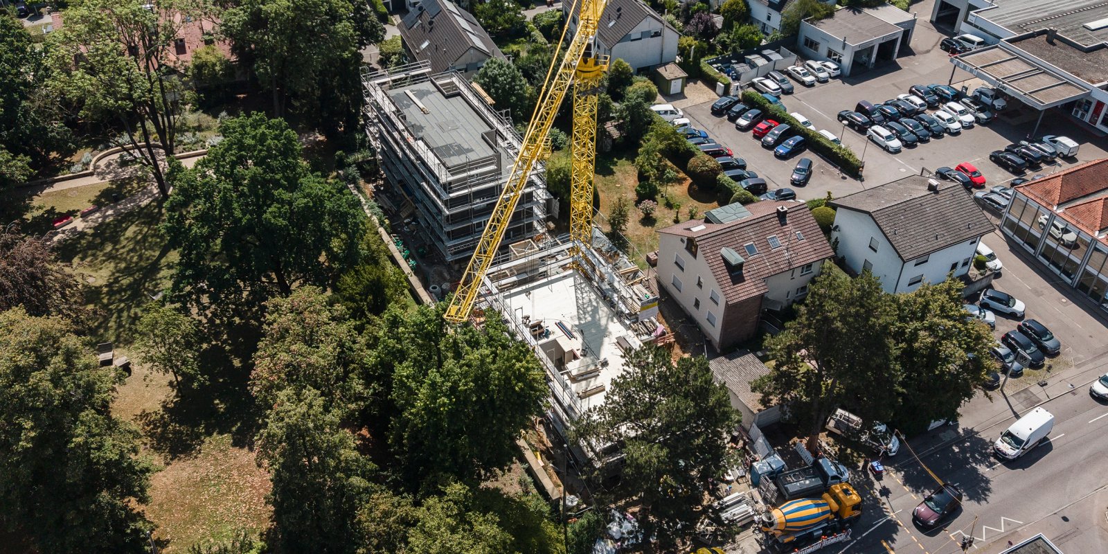 Luftaufnahme der Baustelle für Wohnungen für Landesbedienstete in Stuttgart-Möhringen mit Baukran und mehrgeschossigem Gebäude.
