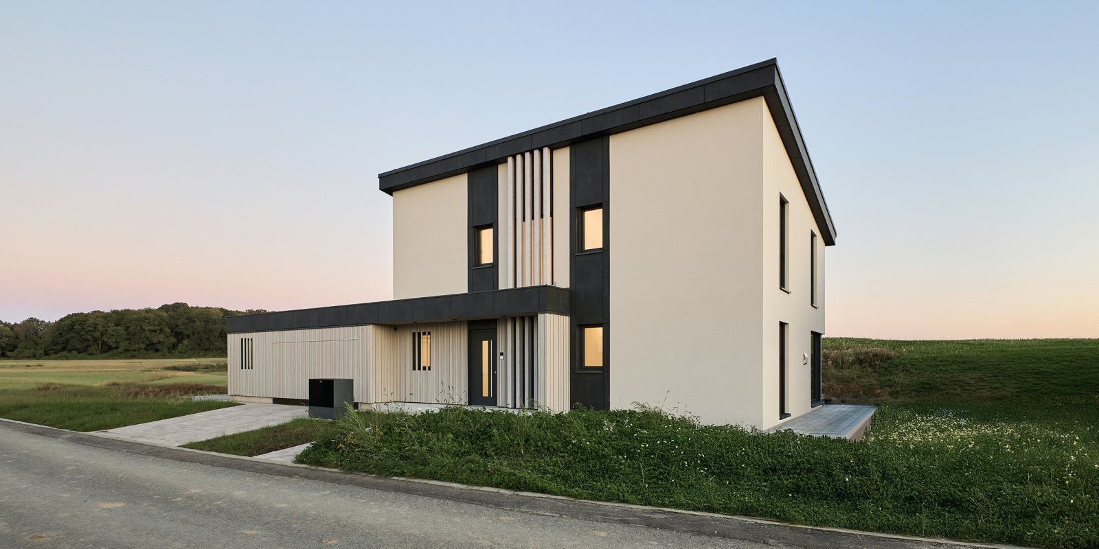 Modernes Einfamilienhaus in Holzbauweise mit Putz- und Holzfassade, klaren Kubaturen und reduziertem Farbkonzept