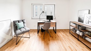 Modern gestaltetes Arbeits- oder Gästezimmer mit Schreibtisch, Bücherregal und großem Fenster – vielseitig nutzbarer Raum der Wohnung.