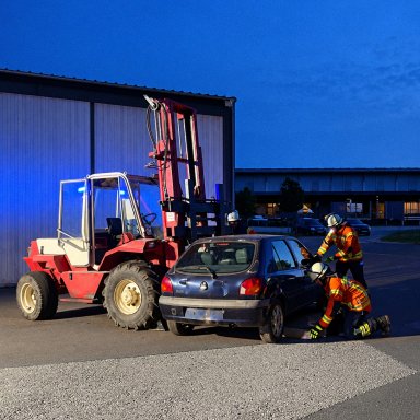 Einsatzkräfte der Feuerwehr üben auf dem Gelände von Bauer Holzbau die Rettung nach einem simulierten Verkehrsunfall zwischen einem Stapler und einem Auto.